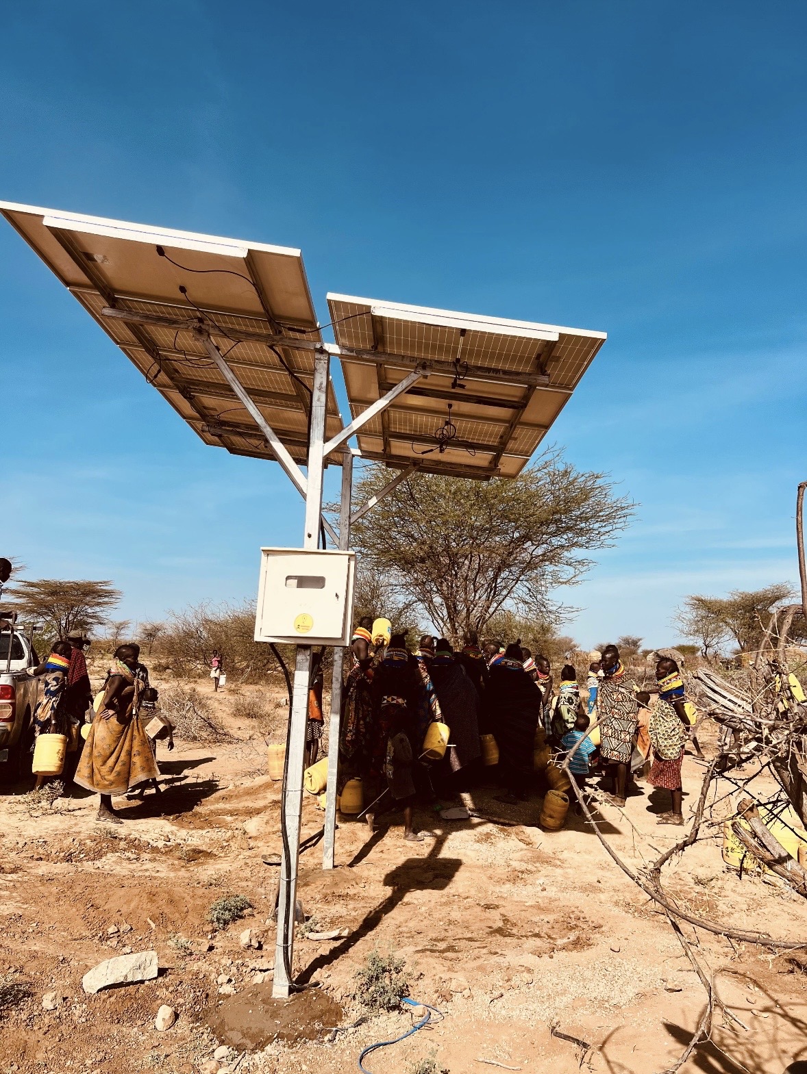 Solar-powered community water point with families filling jerrycans Chumvi Laikipia