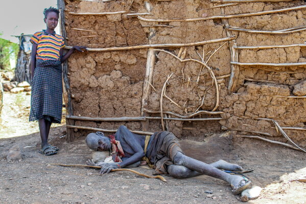 Elderly Turkana resident weakened by drought outside a traditional manyatta