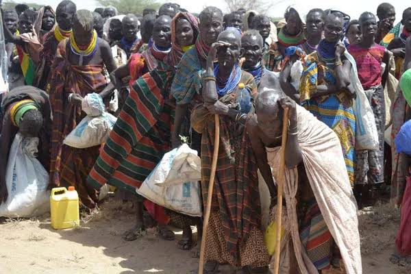 Large crowd of Turkana elders gathered during drought with jerrycans and aid sacks